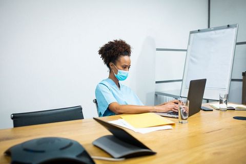 Healthcare Worker in Mask Using Laptop in Meeting Room - Download Free Stock Images Pikwizard.com