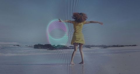 Joyful Woman Dancing on Sunny Beach in Yellow Dress