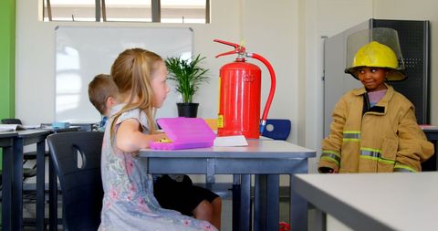 Children in school learning from firefighter demonstration