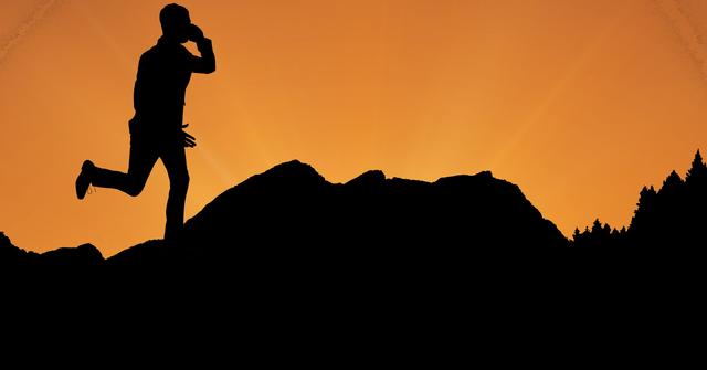 Digital composite of Silhouette executive using phone while running on mountain against orange sky