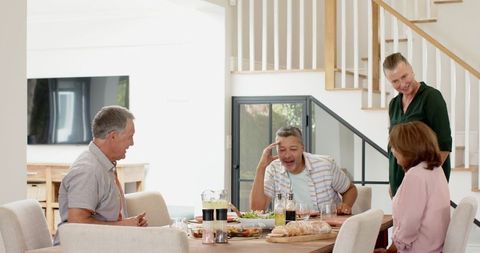 Senior Friends Enjoying Meal Gathering in Modern Home Interior
