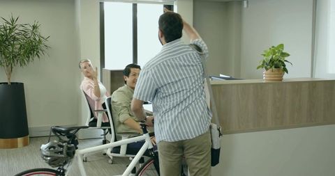 Professional in Casual Attire Greeting Reception Staff with Bicycle