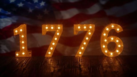 Illuminated 1776 marquee numbers with patriotic flag backdrop