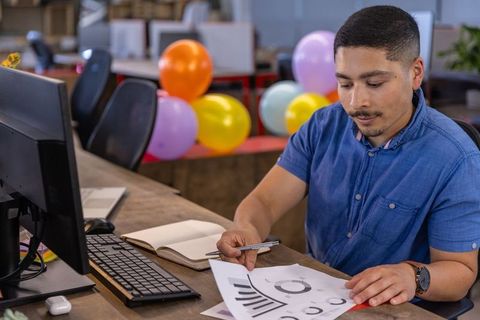Young Professional Analyzing Business Charts at Office Desk