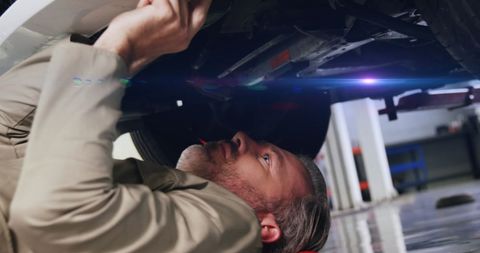 Mechanic Repairing Car Underneath in Modern Garage - Download Free Stock Images Pikwizard.com