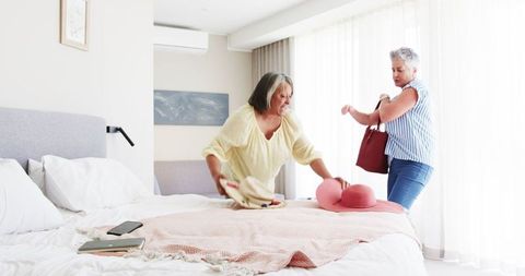 Joyful Senior Lesbian Couple Packing for a Vacation