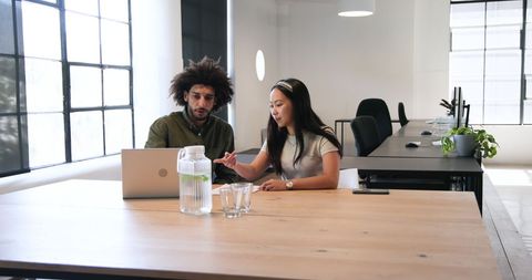 Colleagues Collaborating at Shared Workspace with Laptop