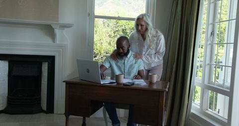 Couple wedding planning with laptop at home