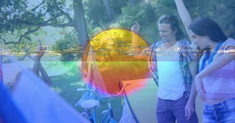 Friends dancing at summer campground near bicycle and tent with vibrant sun glitch overlay