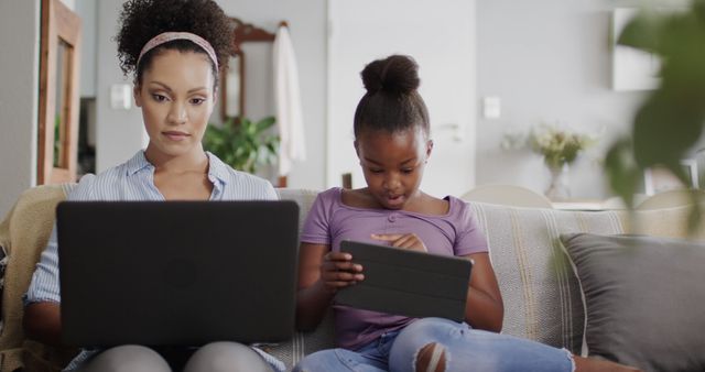 Mother and Daughter Using Laptop and Tablet Together on Sofa - Download Free Stock Images Pikwizard.com