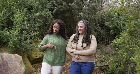 African American Women Walking Through Woodland Trail Sharing Conversation and Bonding