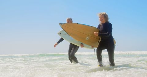 Active Senior Couple Enjoying Surfing at Beach on Sunny Day - Download Free Stock Images Pikwizard.com