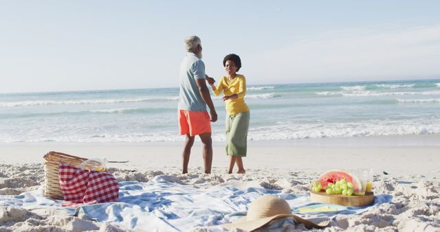 Happy african american couple having picnic and dancing on sunny beach - Download Free Stock Photos Pikwizard.com