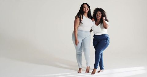 Confident women embracing in minimalist studio space