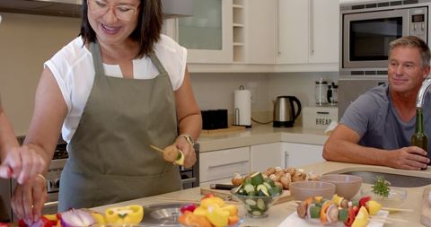 Senior friends preparing vegetables for a healthy meal in modern kitchen