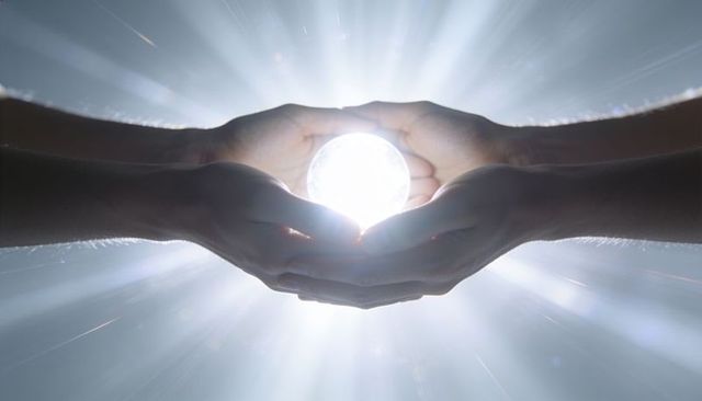 Hands cradling glowing orb radiating light beams minimalist energy concept for unity and hope