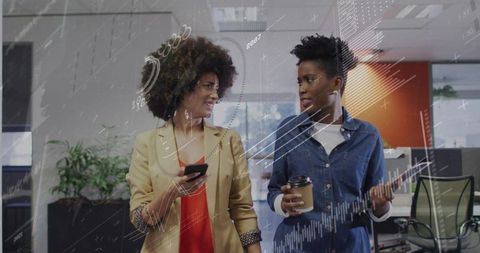 Professional women discussing reports in modern office environment