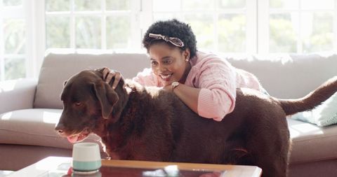 Woman Embracing Labrador in Sunlit Living Room