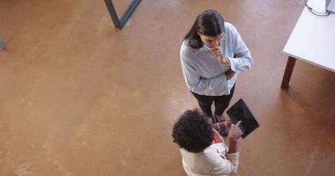 Diverse Female Colleagues Analyzing Data on Tablet in Modern Office