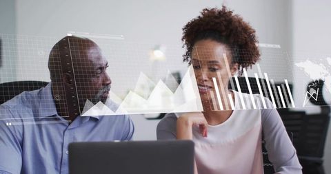Colleagues collaborating on laptop with data overlays and charts in modern office workspace