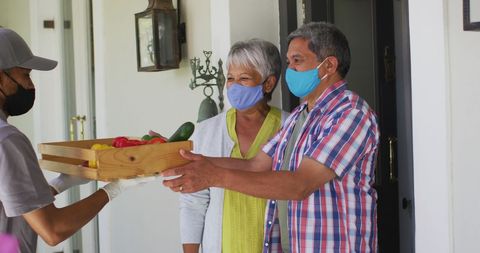 Senior couple receiving fresh produce delivery during pandemic