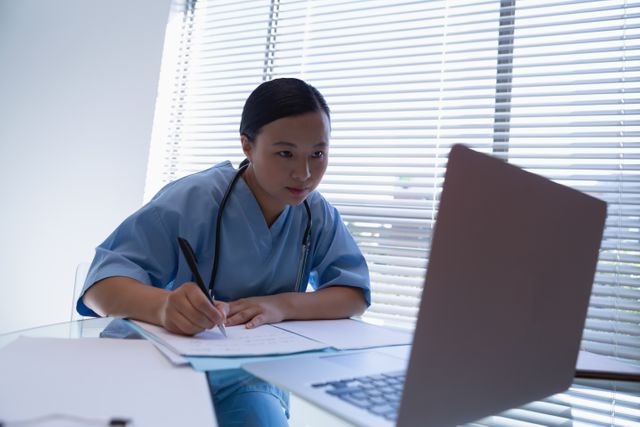 Front view of female surgeon working at desk in clinic at hospital 