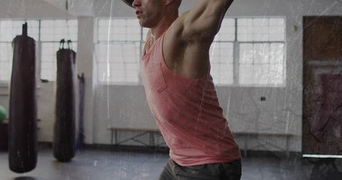 Muscular athlete performing overhead press in gym