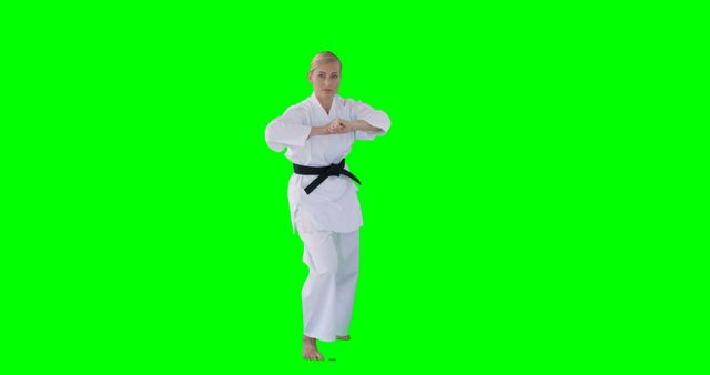 Woman in Karate Gi Practicing Martial Arts Against Green Background - Download Free Stock Images Pikwizard.com
