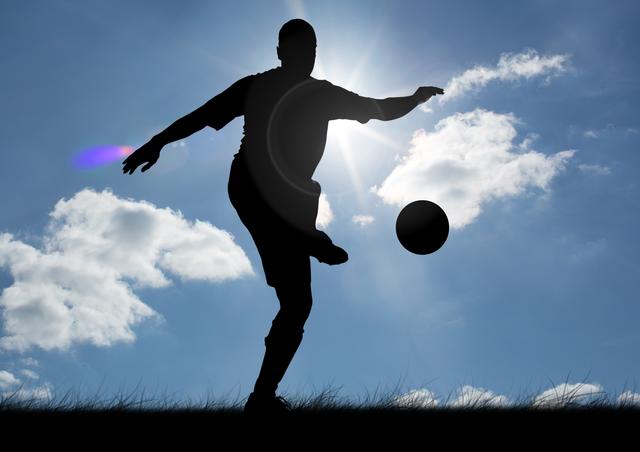Silhouette of man playing football against sunny sky