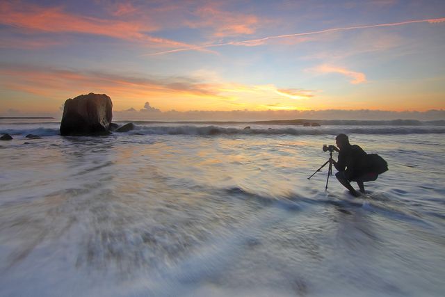 Photographer Capturing Seaside Sunrise with Camera on Tripod - Download Free Stock Photos Pikwizard.com