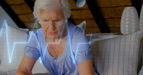 Elderly woman analyzing heart health with digital cardiograph