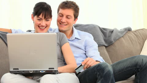 Happy Couple Shopping Online from Comfortable Couch