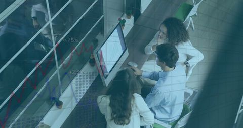 Diverse Team Analyzing Financial Data on Computer Screen in Office