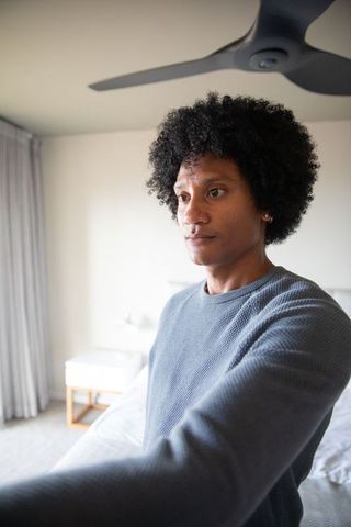Man Relaxing in Minimalist Bedroom Setting Near Bed