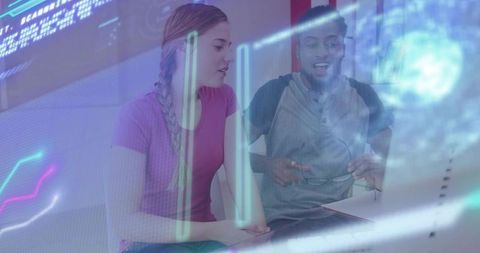 Young professionals collaborating over laptop analyzing holographic data visualization