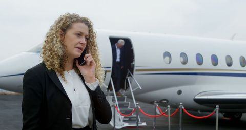 Businesswoman Discussing on Phone Near Private Jet - Download Free Stock Images Pikwizard.com