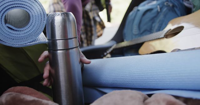 Close-up of Outdoor Gear with Thermos and Guitar Packed for Adventure - Download Free Stock Images Pikwizard.com