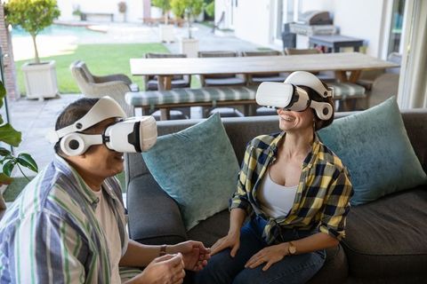 Couple enjoying virtual reality experience on sofa