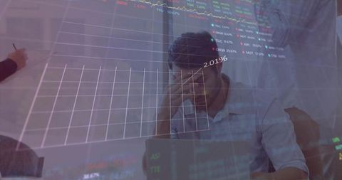 Stressed analyst covering face while working on laptop with stock market charts overlay