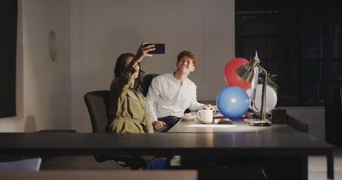 Colleagues Taking Selfie with Balloons in Office