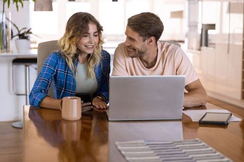 Couple Collaborating on Laptop in Bright Kitchen