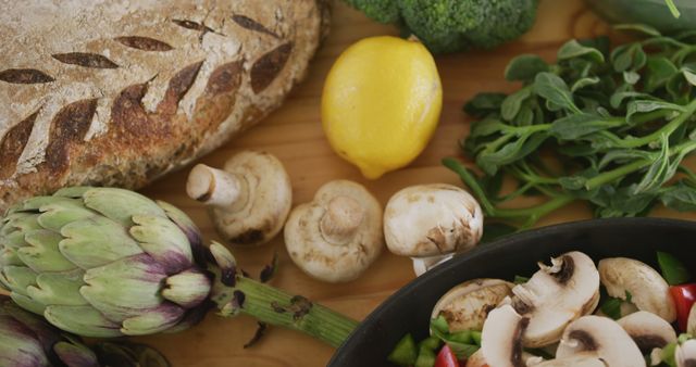 High angle close up of a bowl filled with mouth watering freshly chopped vegetables, with mushrooms, bread, a lemon and other ingredients standing on a wooden cooking table, in slow motion