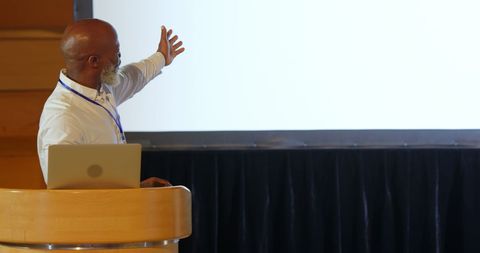 Senior Businessman Giving Presentation at Conference Talk