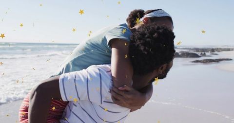 Couple piggybacking on sunny beach shoreline with playful gold star overlay