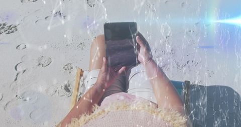 Senior Woman Using Smartphone While Relaxing on Sunny Beach