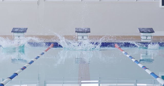 Splashes of swimmers swimmers racing in lanes at indoor swimming pool, copy space. Competition, training, fitness, exercise, healthy lifestyle, sport, swimming and swimming pool, unaltered.