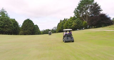 Golf Enthusiasts Enjoying a Day on Fairway With Golf Carts