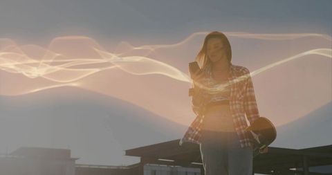 Skater Woman Checking Smartphone on Rooftop at Sunset with Cinematic Light Trails