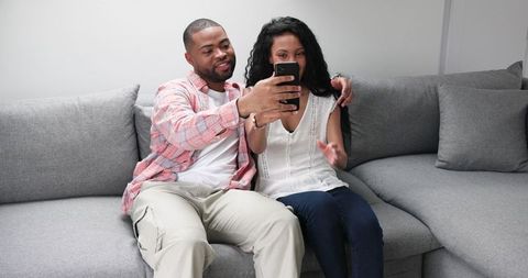 Happy couple announcing engagement via smartphone call