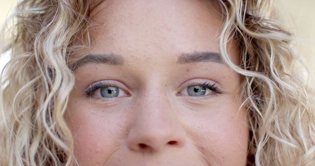 Close-Up of Young Woman's Face with Curly Hair and Natural Makeup - Download Free Stock Images Pikwizard.com